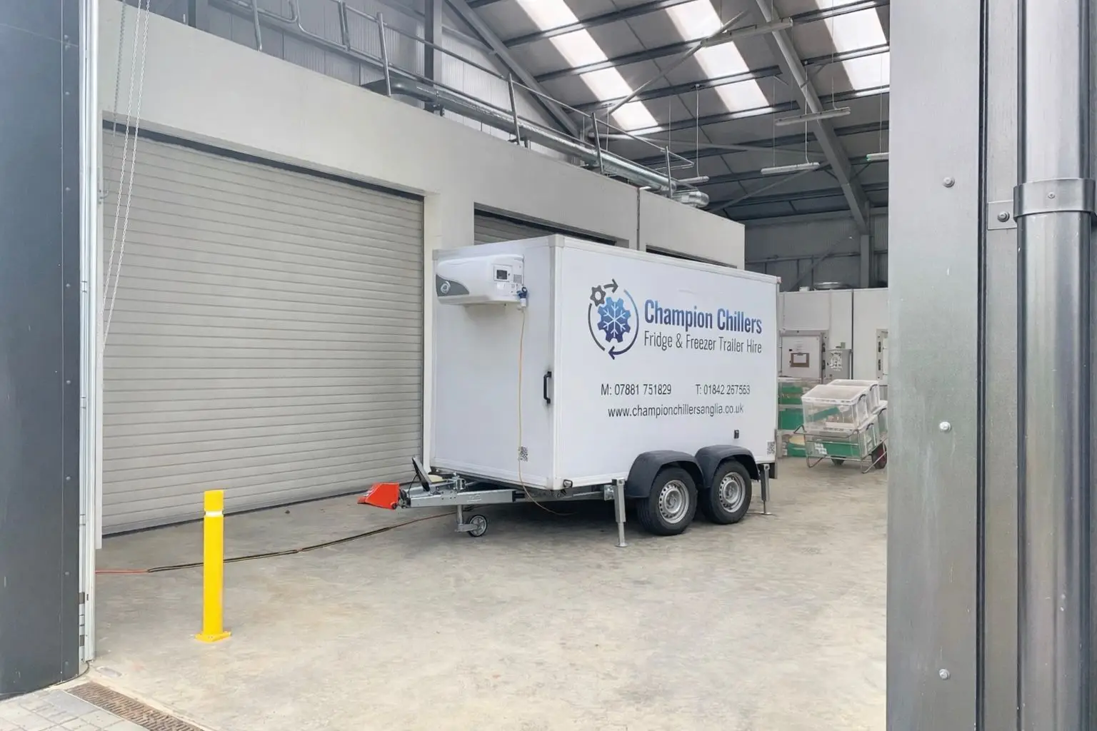 Champion Chillers fridge and freezer trailer hire unit parked inside a commercial warehouse unit.