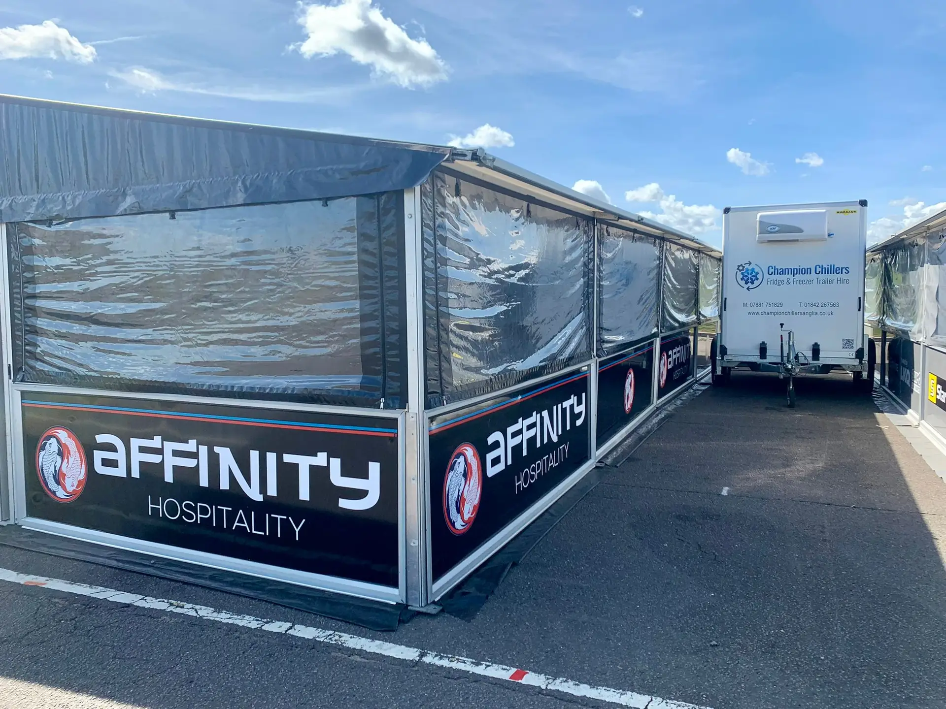 Champion Chillers fridge and freezer trailer hire unit parked beside an Affinity Hospitality trackside marquee.