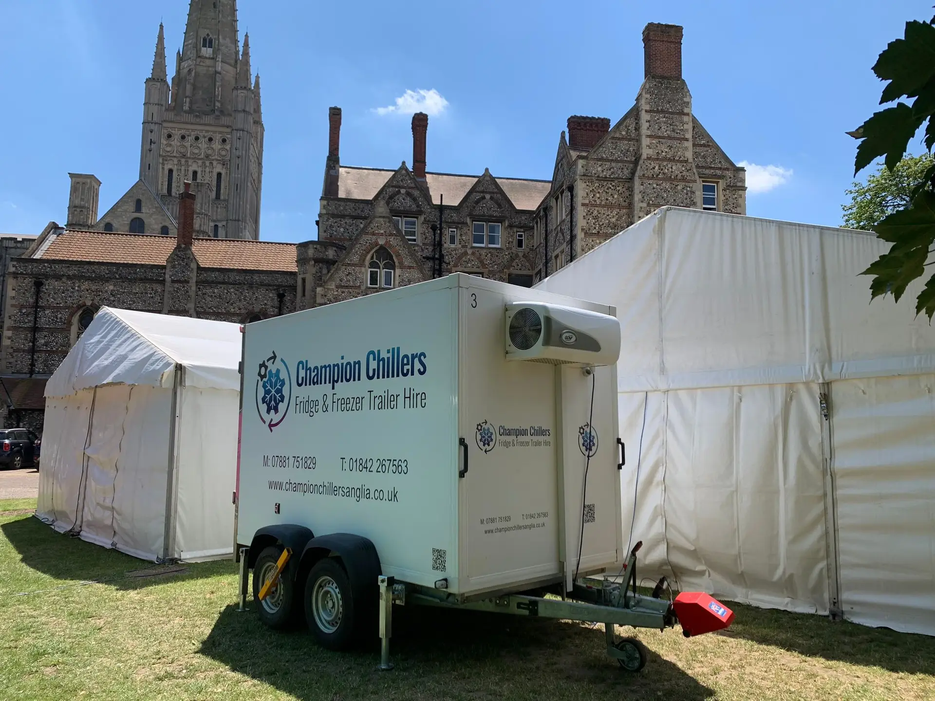 Champion Chillers fridge and freezer trailer hire unit beside marquees, with a cathedral spire in the background.